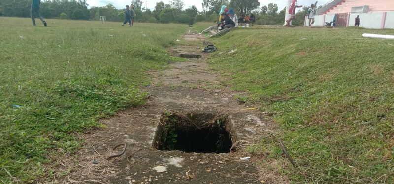 Saluran Air di Lapangan Sepak Bola Banyak Berlubang